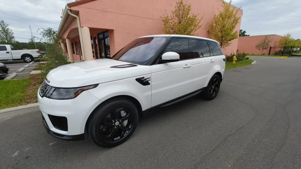 White Range Rover Sport with dark tint, side profile